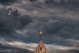 Die Kirchturmspitze von Wierum hinter dem friesischen Wattendeich