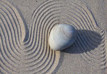 Stein auf Linien im Sand von Karina Baumgart