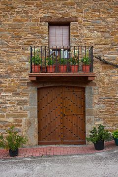 Door with decoration of wrought-iron rivets in the door and a balcony by Ton Van Zeijl