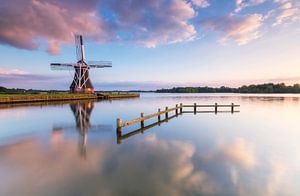 Landschap, zonsondergang bij molen met weerspiegeling in het water van Marcel Kerdijk
