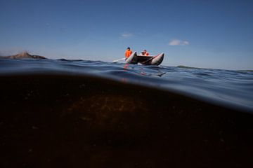 Katamaran Boot segelt über einen Unterwasserfelsen Unterwasserfoto in der Hälfte des Wassers Skandin von Michael Semenov