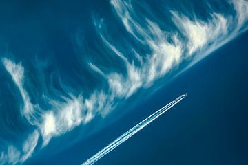 Flugzeug gegen blauen Himmel und Wolken von Patrick Ouwerkerk