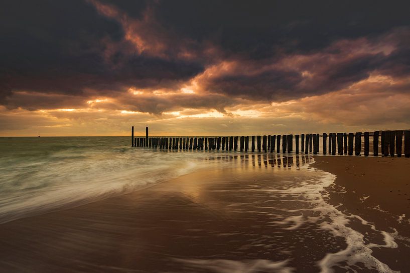 Nuages hollandais et brise-lames typiques de poteaux en bois le long de la côte zélandaise par gaps photography