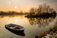 Broken rowboat anchored on riverbank on cold winter morning by Robert Ruidl thumbnail