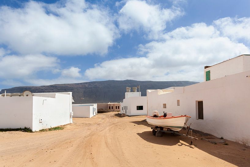 Lege straat van zand met witte huizen en een trailer met boot in Caleta de Sebo op het eiland La Gra van Peter de Kievith Fotografie