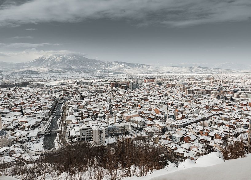 Besneeuwde stad Prizren van bovenaf in het winterseizoen van Besa Art