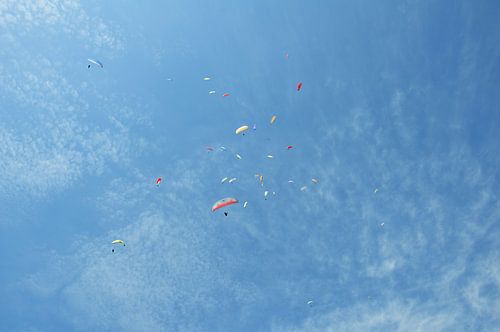 Nepal, Pokhara: Paragliders cirkelen in een stijgende stroming boven de berg Sarangkot. Blauwe lucht