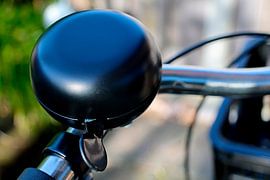 A matt black bicycle bell on a modern city handlebar, perfect for an urban lifestyle by Dlanor