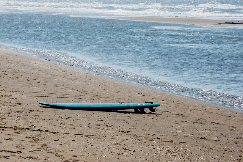 Blauwe surfplank aan zee van Blond Beeld