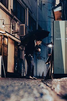 Homme japonais devant un distributeur automatique