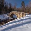 Pont d'hiver dans une forêt enneigée sur fernlichtsicht