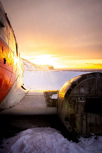 DC-3 vliegtuigwrak in besneeuwd landschap bij zonsondergang, Eyvindarholt, IJsland