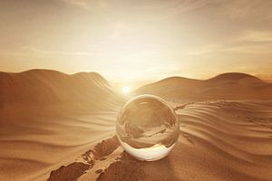 Boule de verre sur le sable du désert à côté d'empreintes de pas sur Besa Art