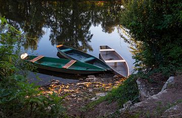 drie houten bootjes in een rivier aan de oever