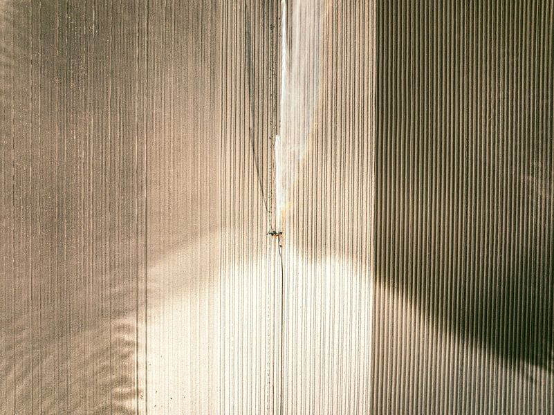 Irrigation pivot gun machine spraying water on a field during a dry summer by Sjoerd van der Wal Photography