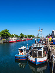 Uitzicht op de Alter Strom met vissersboot in Warnemünde