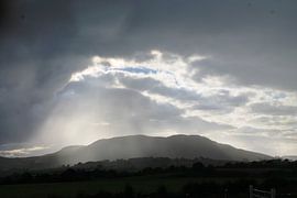 Breaking open cloud cover over the mountains Ireland by Yria Meijer