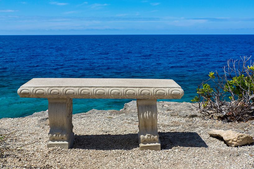 Lege betonnen bank aan kust van het eiland Bonaire met blauwe zee van Ben Schonewille