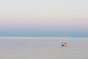Pastellfarbener Sonnenuntergang mit Segelboot