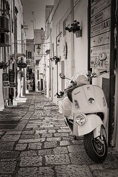 Vespa-Roller in einer Strasse in Italien in Sepia