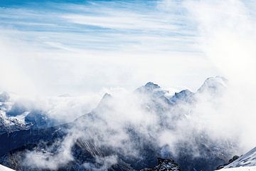 Hoge bergen steken door de wolken in de Oostenrijkse alpen van Hidde Hageman