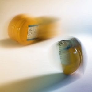 gele schroefdoppen gemaakt van aluminium en plastic voor flessen in motieonscherpte op een lichte ac