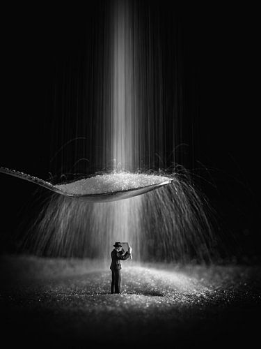 Miniature people: mister reads a newspaper and takes shelter under a roof while it rains