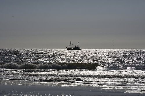 Noordzee strand met vissersboot.