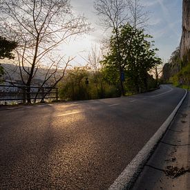 Lumière du soir sur une route déserte avec une paroi rocheuse à côté sur FHoo.385