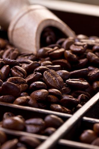 Des grains de café dans un tiroir en bois