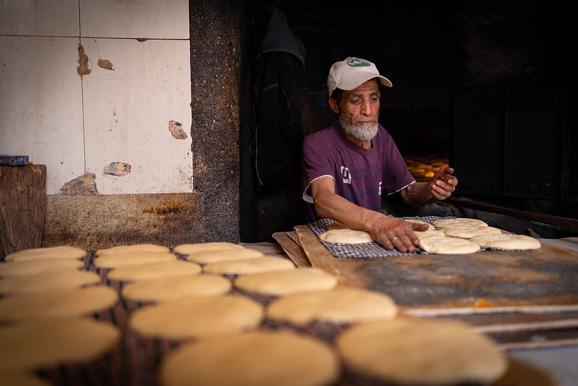 Un boulanger sort des pains du four à Marrakech par Teun Janssen