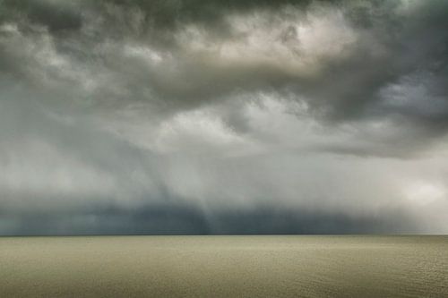 Donkere hagelwolken boven een kalme waddenzee