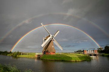 big double rainbow over Dutch windmill in summer rain