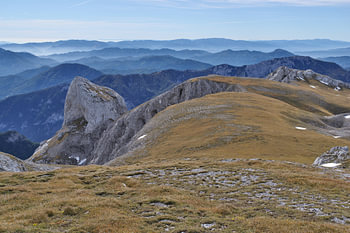 Mountain peaks with rocky terrain and wispy autumn mists