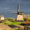  Dutch windmills against the dark threatening sky by Inge van den Brande