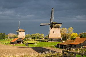 Moulins à vent hollandais contre le ciel menaçant sombre sur Inge van den Brande