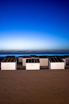 Foto van strandhuisje aan de zee in Oostende bij avond. van Therese Brals