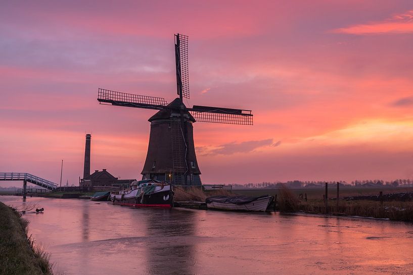 De Kaagmolen in Spanbroek (Noord-Holland) onder een felgekleurde hemel bij zonsopkomst. van Bram Lubbers