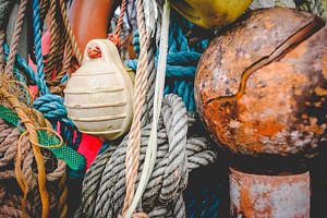 Nahaufnahme von Strandgut aus dem maritimen Bereich: Seile, Fischernetze und Bojen