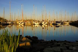 Reflections of boats in a harbour.