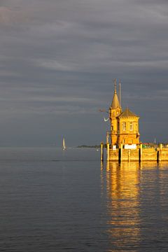 Konstanz aan het Bodenmeer, haveningang met vuurtoren, schepen, weerspiegelingen bij oranje zonsondergang van Andreas Freund