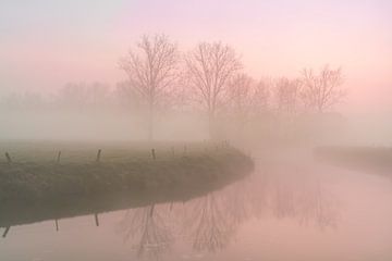 ijzige ochtend met mist die opstijgt langs een rivier