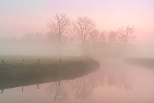 ijzige ochtend met mist die opstijgt langs een rivier
