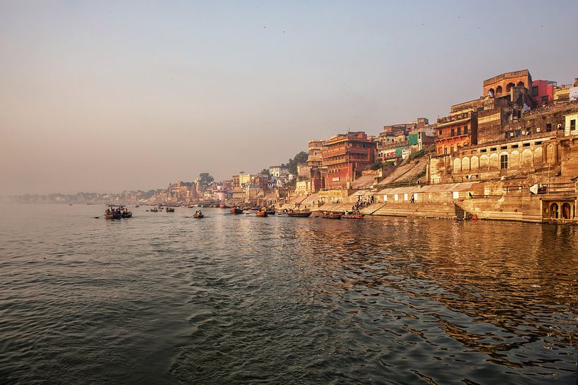 Varanasi Ganges rivier ghat met oude architecturale gebouwen en tempels gezien vanaf een boot op de  van Tjeerd Kruse