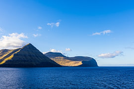 Blick auf Felsen der Färöer Insel Eysturoy mit Wolken von Rico Ködder