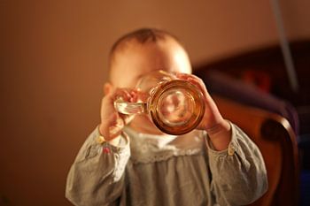 Baby Drinking from a Large Glass Mug