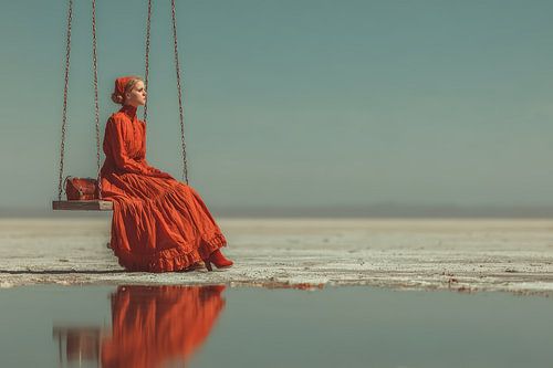 surrealistisch portret vrouw op schommel aan het strand