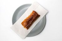 Warm saucijzenbroodje op een bord.