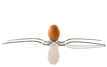 een ei balanceert op twee vorken