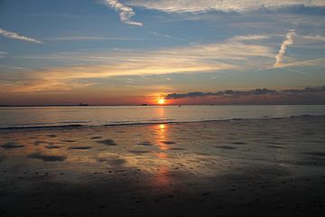 Kleurrijke zonsondergang met reflectie op strand van Mireille Zoet